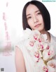 A woman holding a bunch of white orchids in her hands.