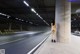 A naked woman standing in the middle of a parking garage.