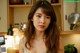 A woman with long brown hair standing in a kitchen.