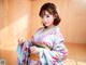 A woman in a blue and pink kimono posing for a picture.