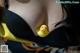 A woman in a black bra with a yellow rubber duck in her mouth.