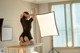 A woman sitting on a table in front of a light.