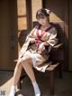 A woman in a kimono sitting on a bench.