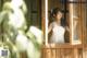 A woman in a white dress looking out of a window.